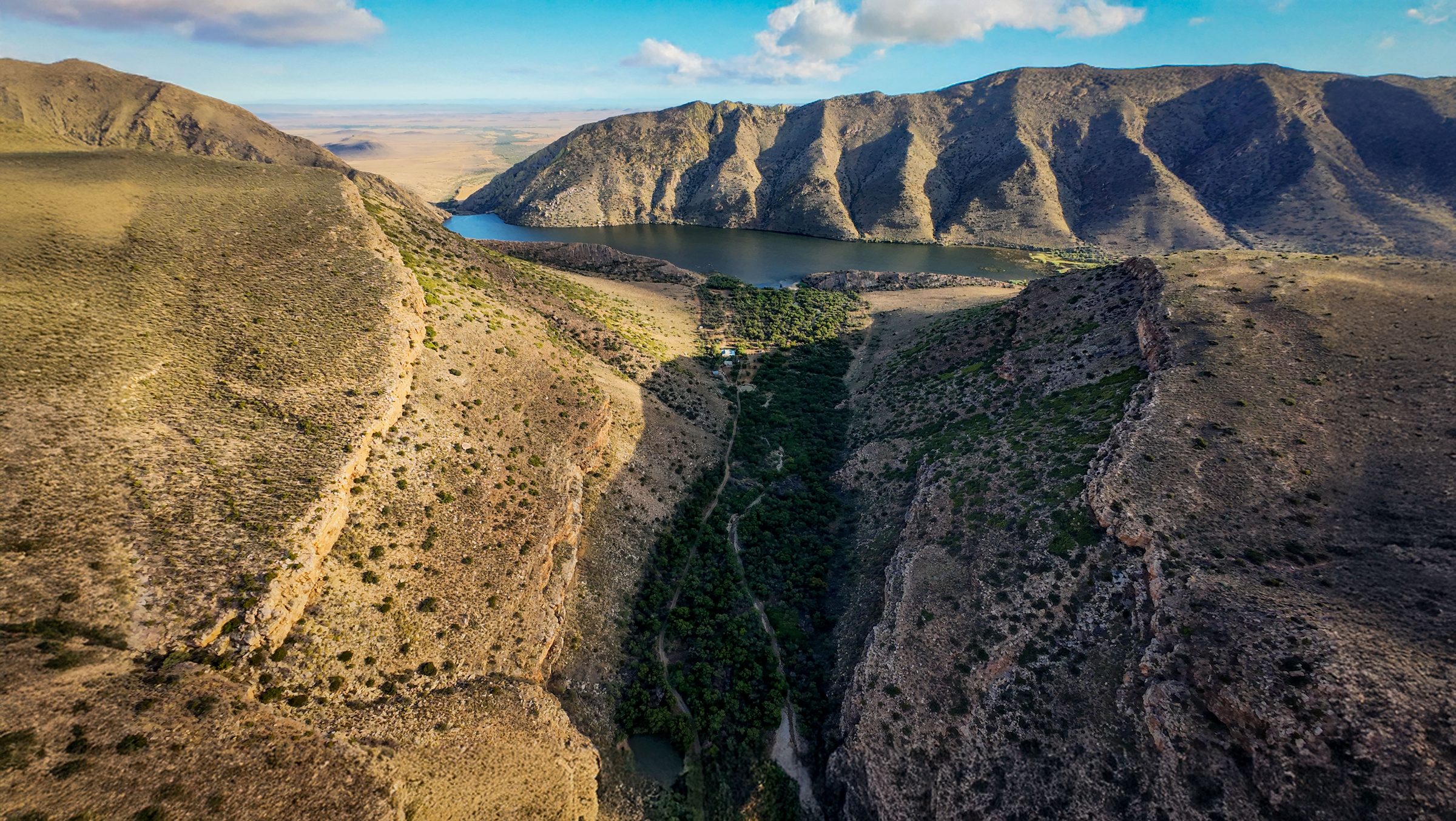 Aerial view of the Krantzkloof gorge, its dam and the Swartberg mountains beyond